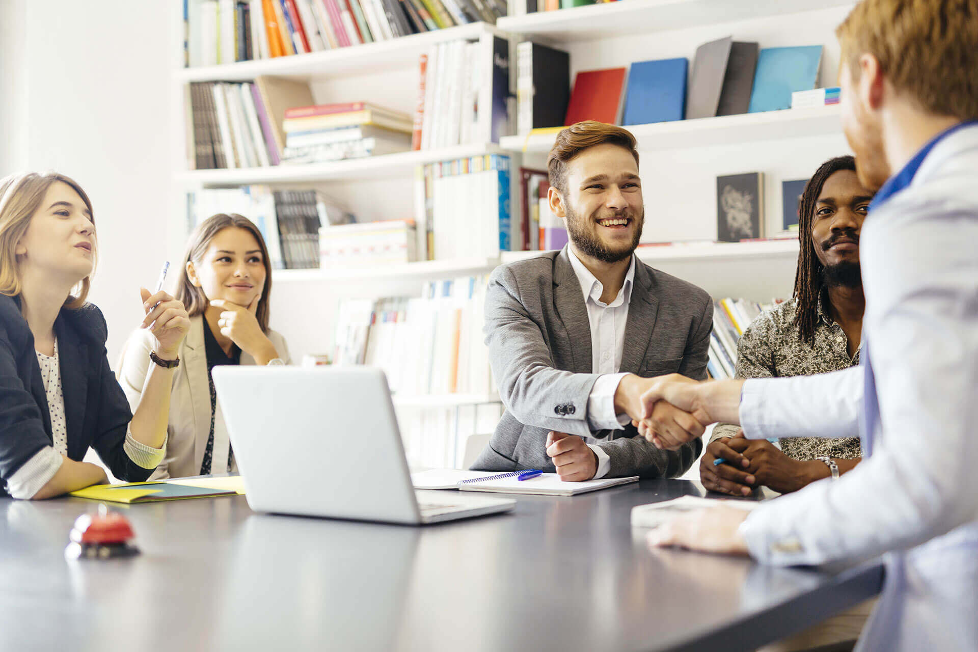 Smiling team shaking hands at meeting