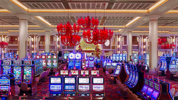 Casino floor with slot machines and red chandeliers
