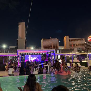 Rooftop pool party at night with stage