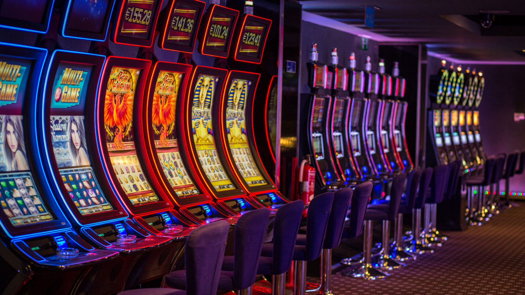 Row of illuminated casino slot machines