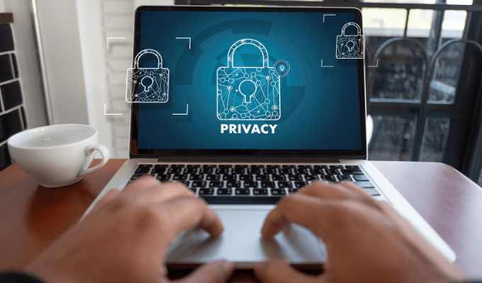 Hands typing on laptop displaying privacy locks