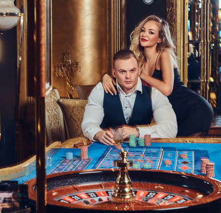 Glamorous couple at roulette table with chips