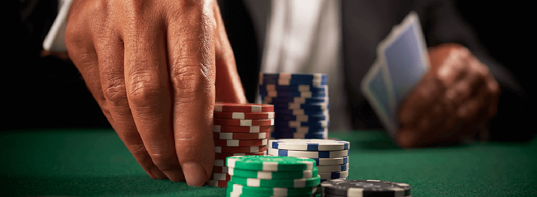 Player stacking poker chips on green felt