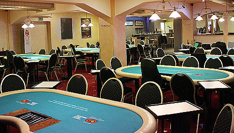 Empty casino poker room with teal tables