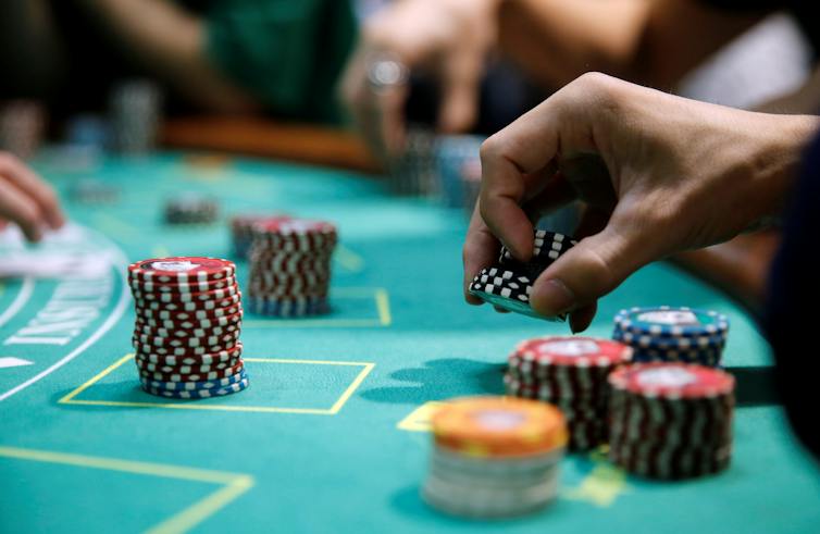 Hand placing poker chips on casino table