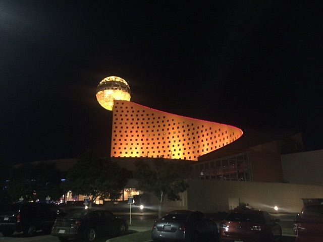 Night view of illuminated orange building with orb
