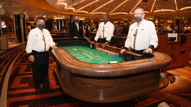 Three masked dealers at casino gaming table