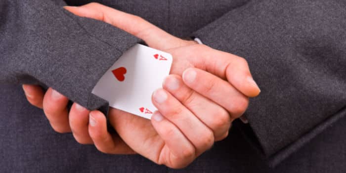 Person pulling ace of hearts from sleeve