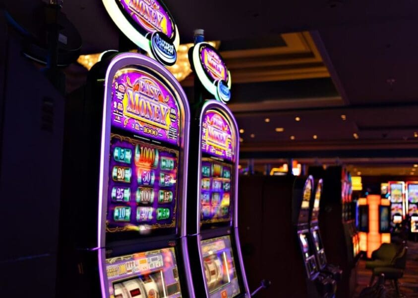 Row of illuminated slot machines in casino