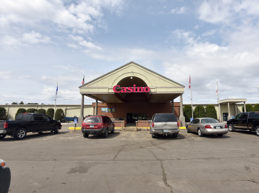 Casino entrance with parked cars and flags